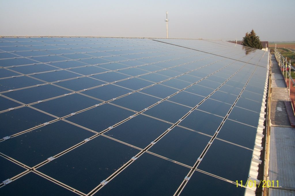 Große Photovoltaikanlage auf einem Flachdach bei klarem Himmel, Blick über die Modulflächen.